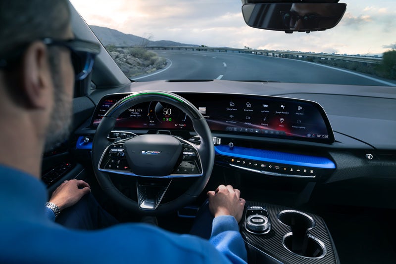 Front View of the 2026 OPTIQ-V Driving Through the Dusk Utilizing its Headlights | Allen Cadillac in Monroe MI